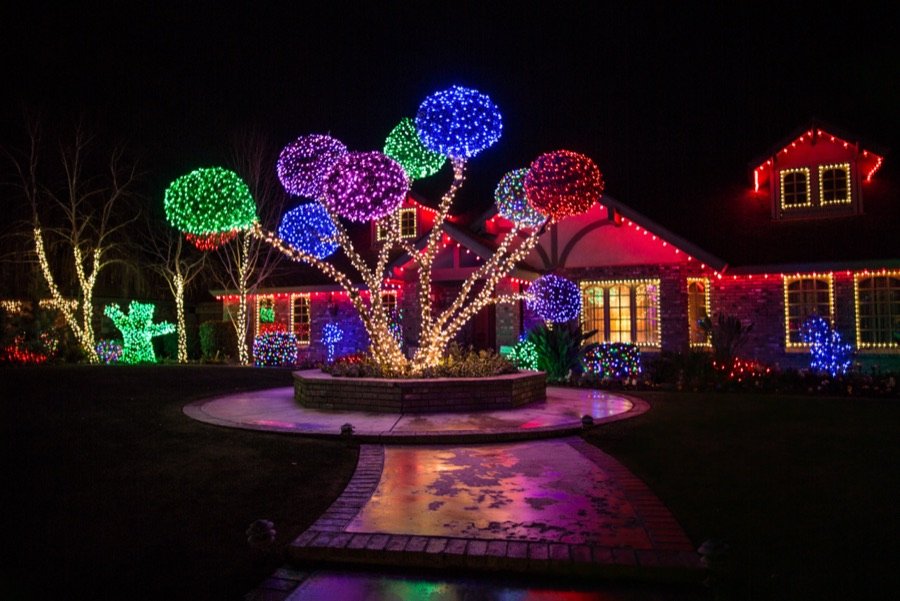 Colorful Christmas front yard lighting with roofline and tree lights