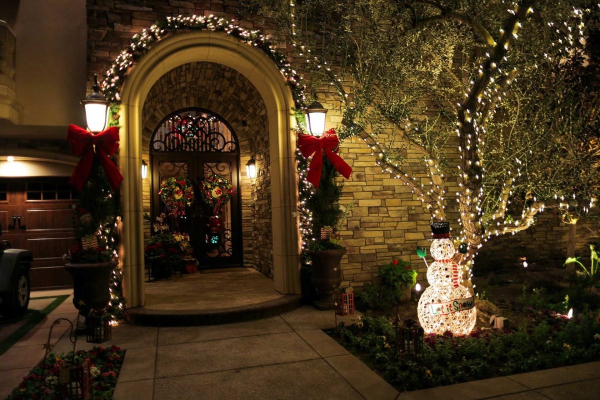Christmas wreath and garland lighting around a front entry