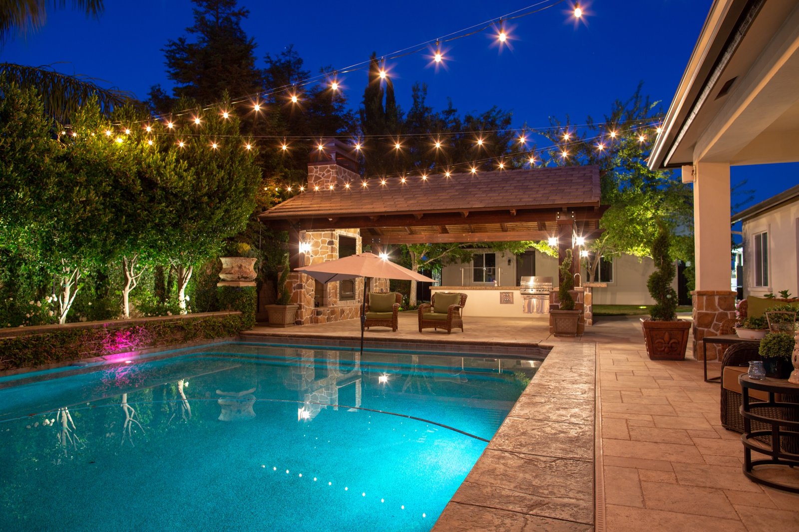 Backyard patio with pool and string lights